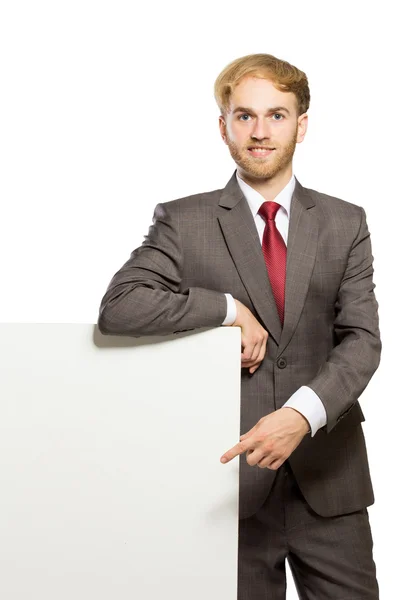 Junger Geschäftsmann, der mit einem leeren Whiteboard steht, isola — Stockfoto