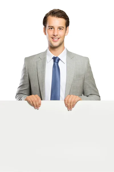 Young businessman standing with a blank whiteboard , isolated — Stock Photo, Image