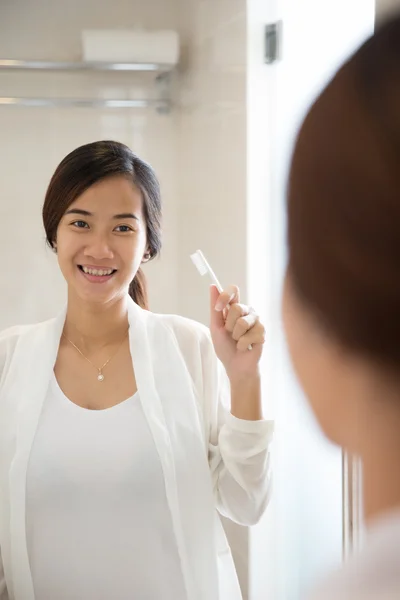 亚洲的年轻女子将愉快地刷她的牙齿 — 图库照片