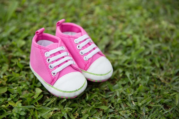 Рожеві кросівки дитяче взуття на дачній ділянці, фон природи — стокове фото