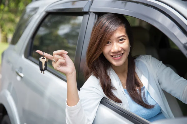 Young asian woman holding a key car on her finger outside the wi — Stock Photo, Image