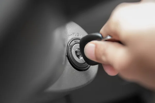 A hand's man plug in a key, starting the engine of a car — Stock Photo, Image