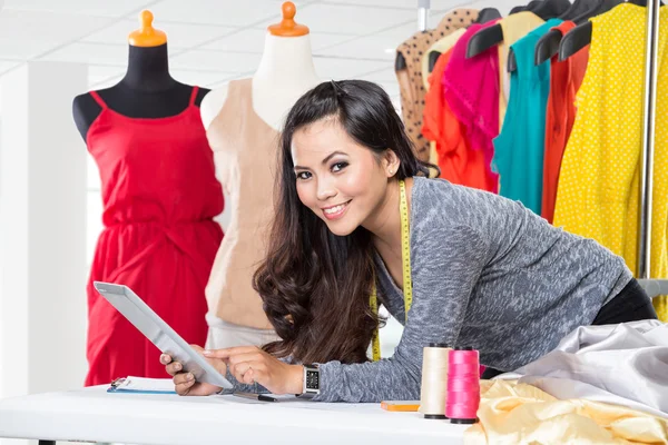 Jeune designer asiatique femme à l'aide d'une tablette pc, souriant reposé sur — Photo