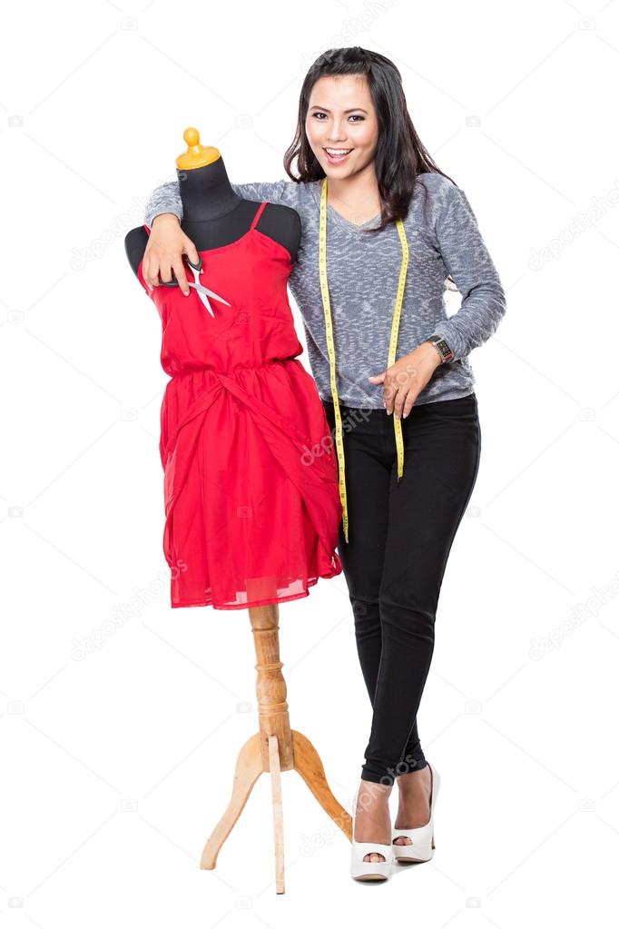 Young asian designer woman posing smiling, hold a scissors,  loo