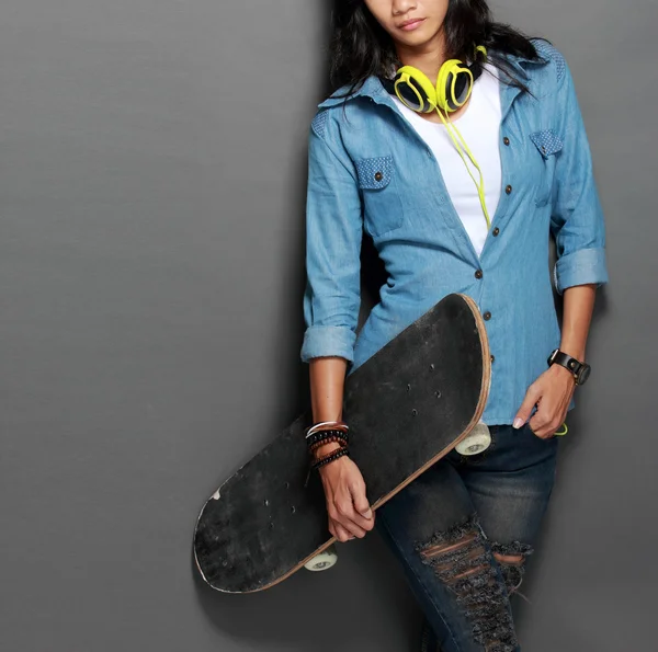 Asiatiska ung skater girl innehar en skateboard — Stockfoto