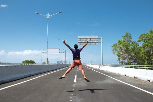 Asian Man jump on the empty highway — Stock Photo, Image