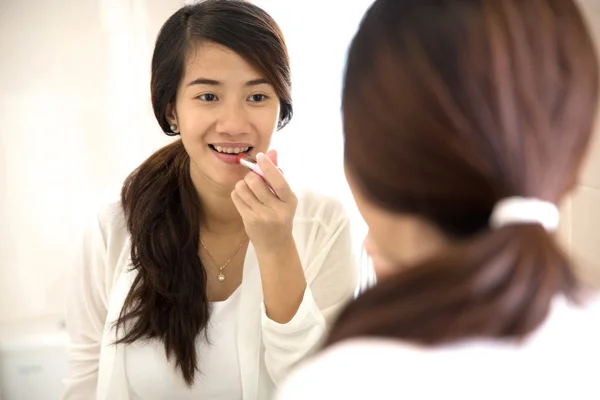 Красивая женщина макияж, нанесение помады на губы — стоковое фото