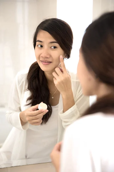 Feliz ásia mulher colocando make-up no, sorrindo no espelho — Fotografia de Stock