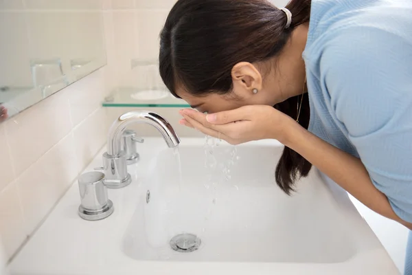 Mujer asiática lavándose la cara en el fregadero — Foto de Stock