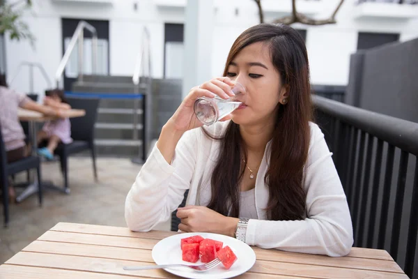 Mulher asiática bebendo água e comendo frutas alegremente, melancia — Fotografia de Stock