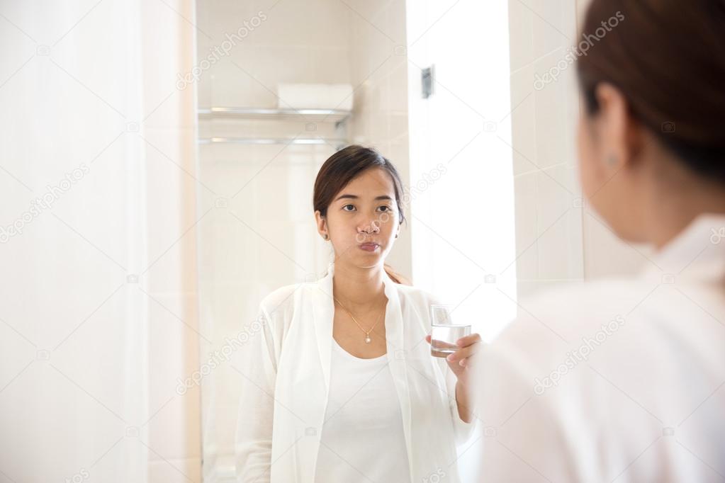 Asian young woman gargle on her mouth after tooth brushing