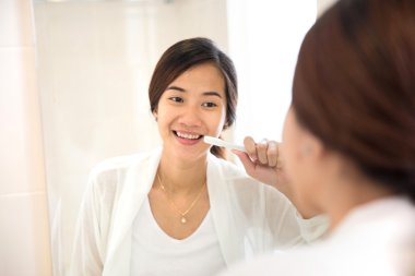 Asyalı genç kadın diş mutlu bir şekilde dişlerini fırça