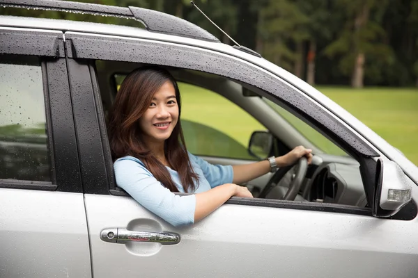 Счастливая молодая азиатка на машине — стоковое фото
