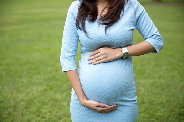 Primer plano asiático embarazada manos en el vientre — Foto de Stock