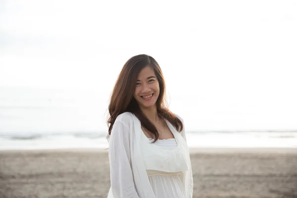 Asiatico donna sorridente a macchina fotografica, godendo di tempo sulla spiaggia — Foto Stock