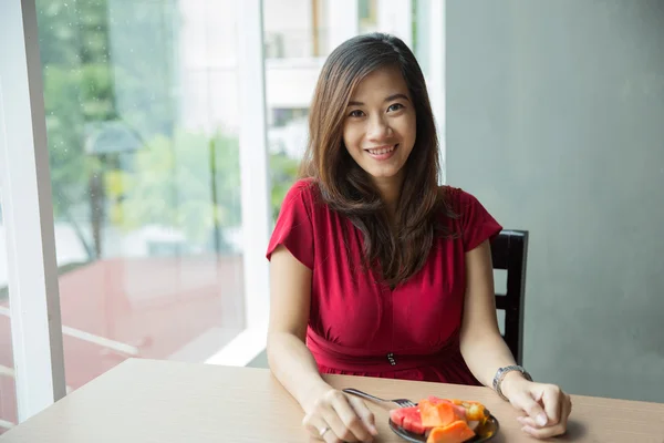 Asian woman eating fruit happily, mixed fruit — Stock Fotó