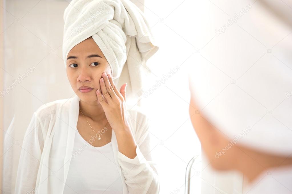 Young Asian woman taking care of her face