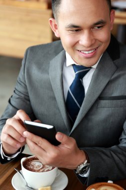 gülümseyen ve bir mobilephone tutan işadamı