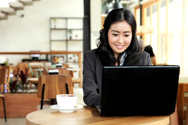 Бізнес-леді працює на своєму ноутбуці під час перерви на каву — стокове фото