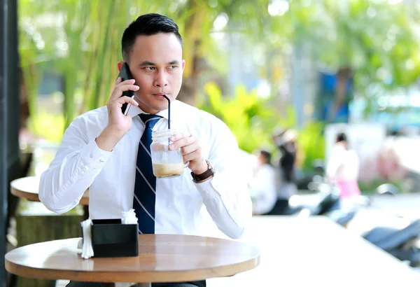 Affärsman dricka medan du talar i telefonen — Stockfoto