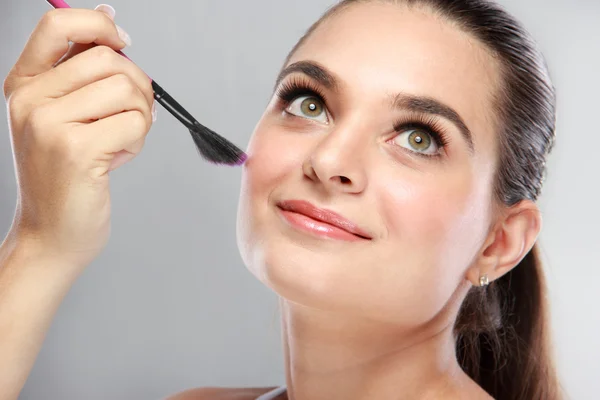 Attraktives Model lächelt, während sie ihr Make-up aufräumt — Stockfoto