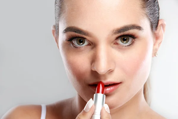 Schönes junges Model, das Lippenstift aufträgt — Stockfoto