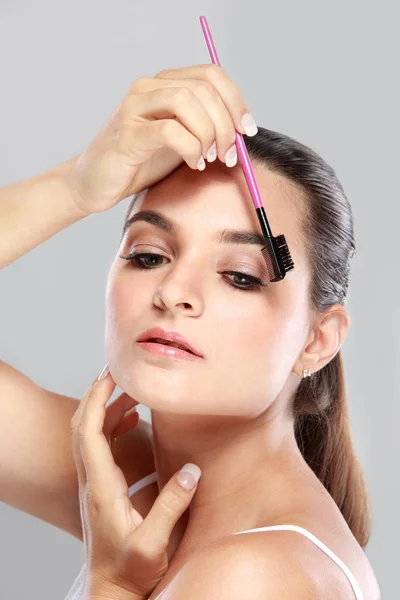 Modelo atractivo usando el peine de las cejas — Foto de Stock