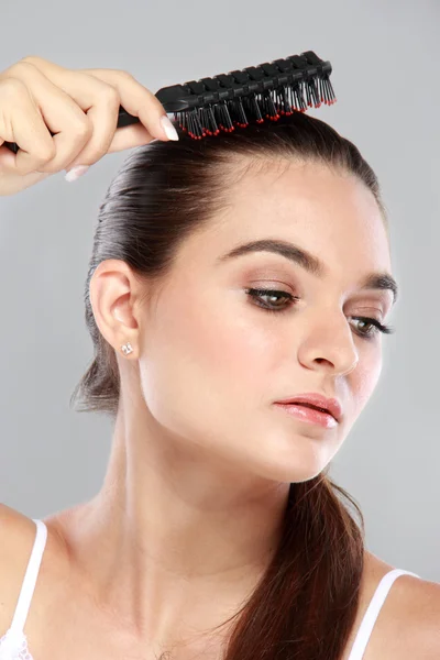 Hermoso modelo con pelo largo peine el cabello — Foto de Stock