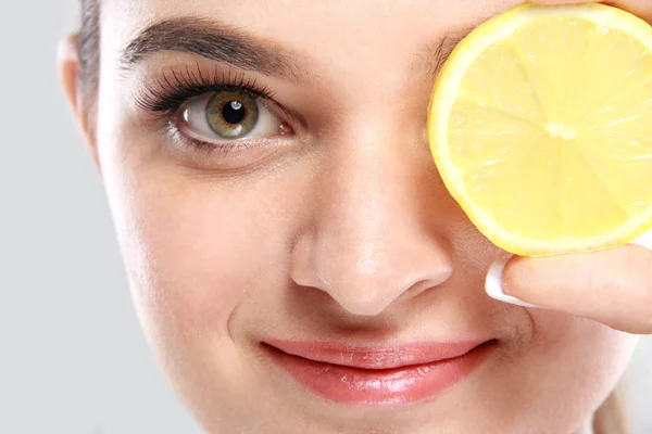 Beautiful caucasian woman holding a slice of lemon — Stock Photo, Image