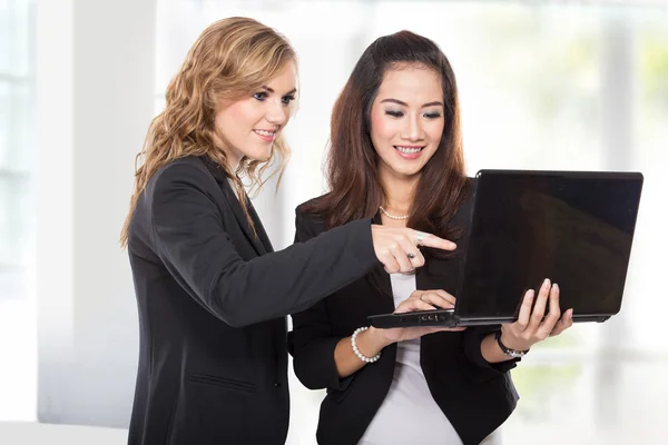 Duas empresárias discutindo algo no laptop — Fotografia de Stock