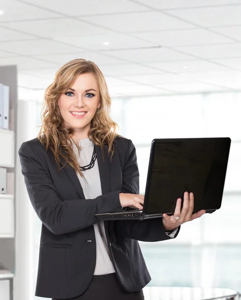 Sorrindo jovem empresária segurando laptop — Fotografia de Stock