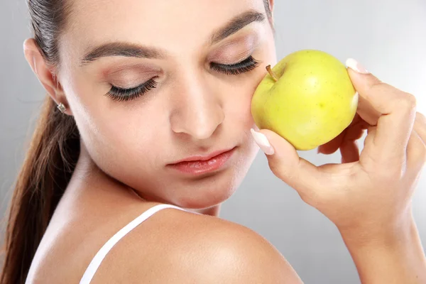 Beautiful woman holding a fresh apple with eyes closed — Stock Photo, Image