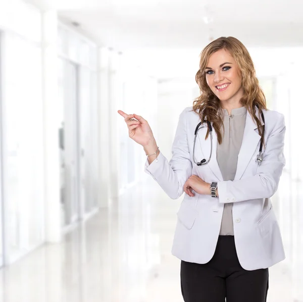 Young female doctor smiling showing blank copyspace — Stock Photo, Image