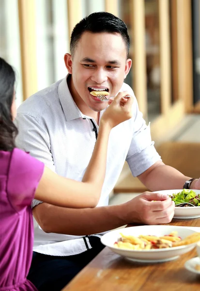 man fed by his girlfriend when have a lunch