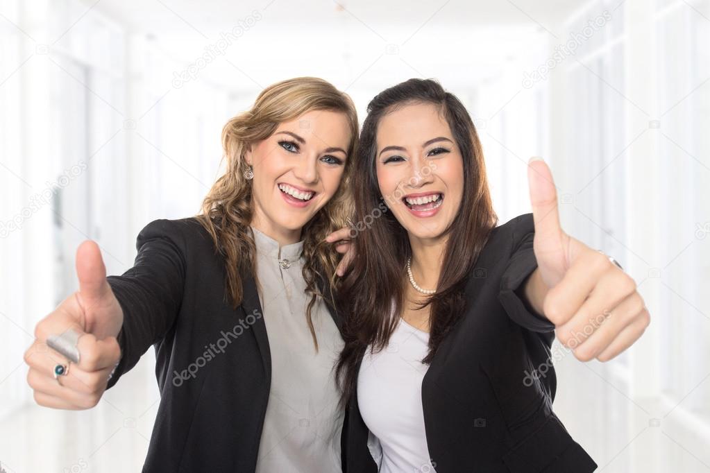 young business woman making thumbs up gesture wearing blouse and