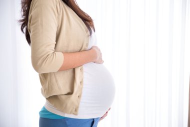 Hamile kadın karnına dokunuyor.