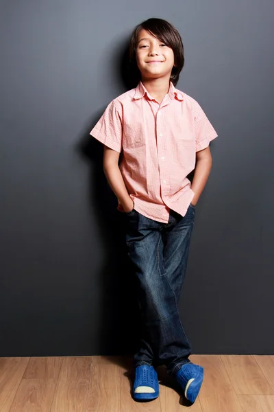Elleri cebinde olan gülümseyen yakışıklı küçük çocuk — Stok fotoğraf