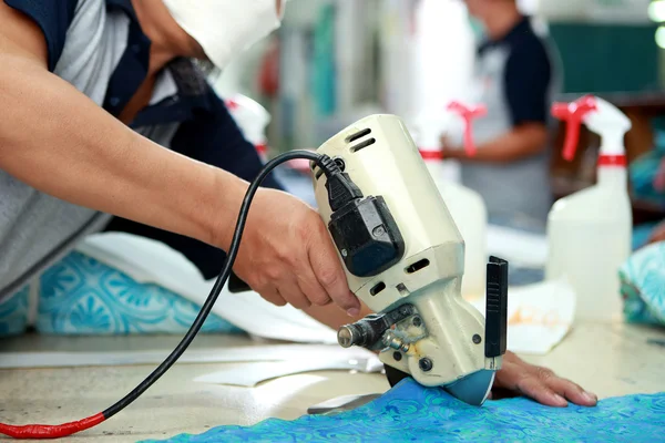 Trabalhador usando máquina de corte para cortar tecidos — Fotografia de Stock