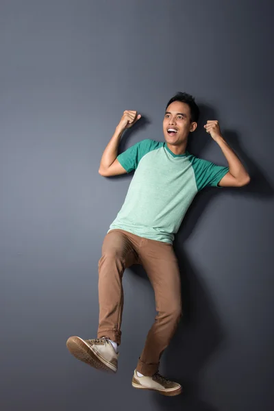 Young man floating and pretending to use a parachute — Stock Photo, Image