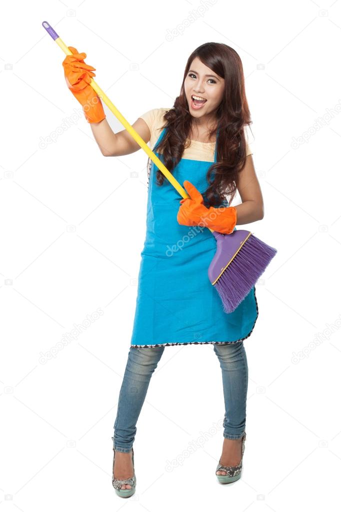 Beautiful young asian woman holding a broom, use it like a guita