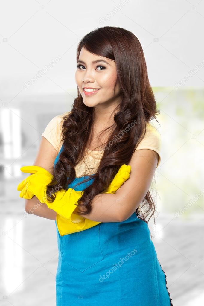 Young asian woman getting ready to do the chores, putting on yel