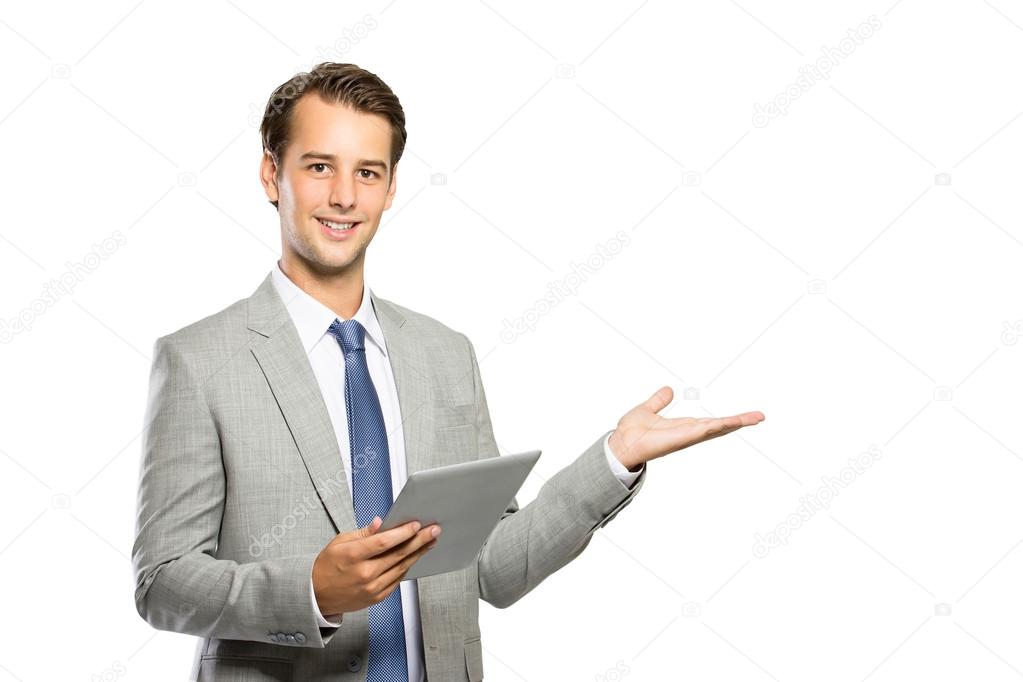 young businessman holding a tablet and presenting copyspace