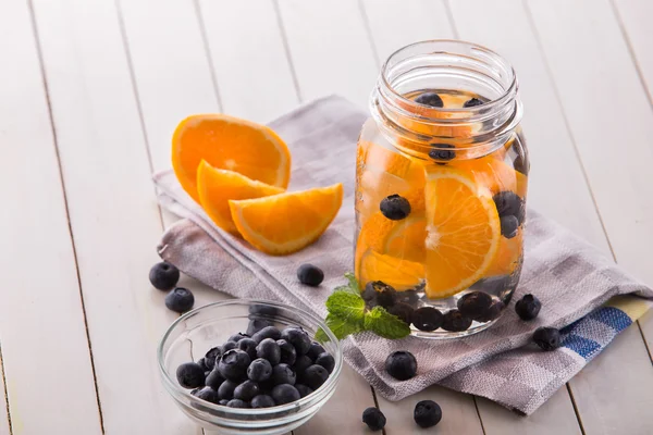 Fruta fresca mezcla de agua infundida con sabor a naranja, arándano y — Foto de Stock