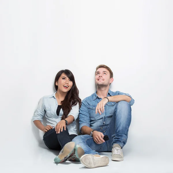 Mixed race couple thinking looking up and sitting on the floor — Stok fotoğraf