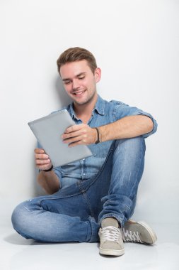 Tablet pc tutan katta oturan genç beyaz adam