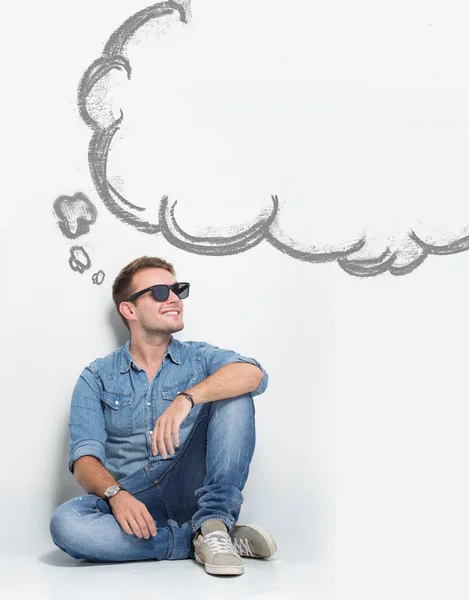 Young caucasian man wear sunglasses while sitting on the floor t — Stock Photo, Image