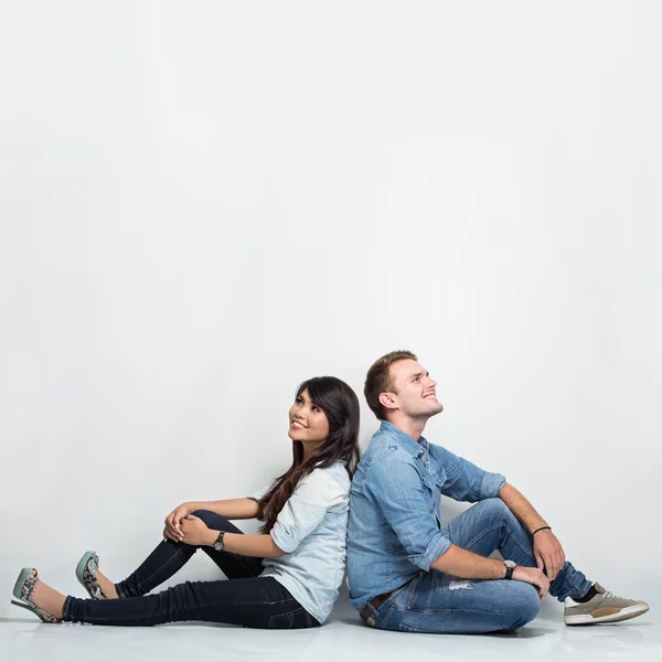 Mixed race couple thinking looking up and sitting on the floor b — Stok fotoğraf