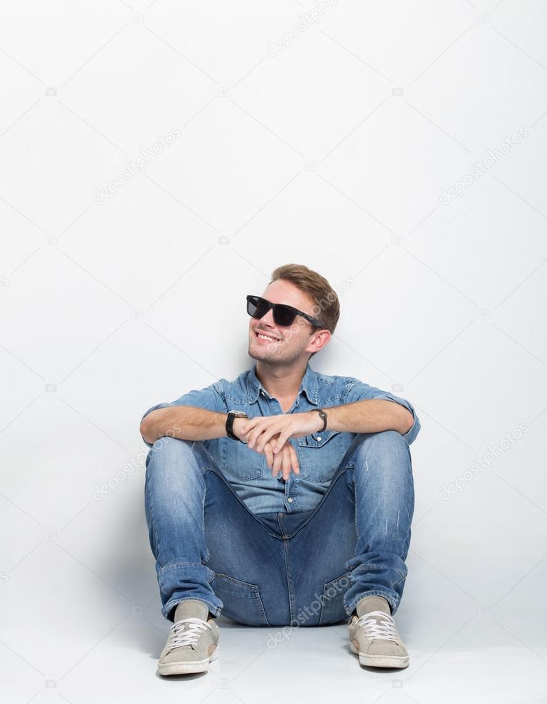 young male looking up and sitting on the floor