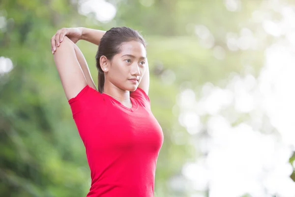 Asian woman doing stretching exercise during outdoor cross train — Stock Photo, Image