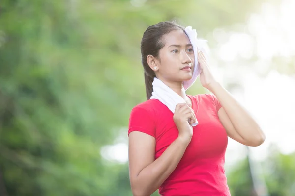 Mujer asiática limpiando su sudor después del ejercicio — Foto de Stock